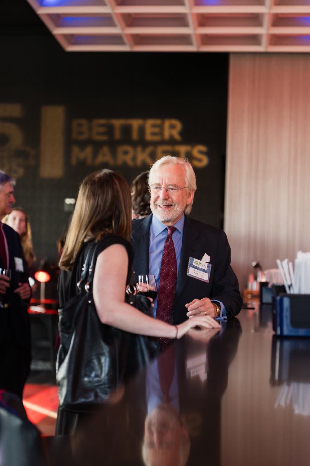 Reception guests talk at a bar during an event