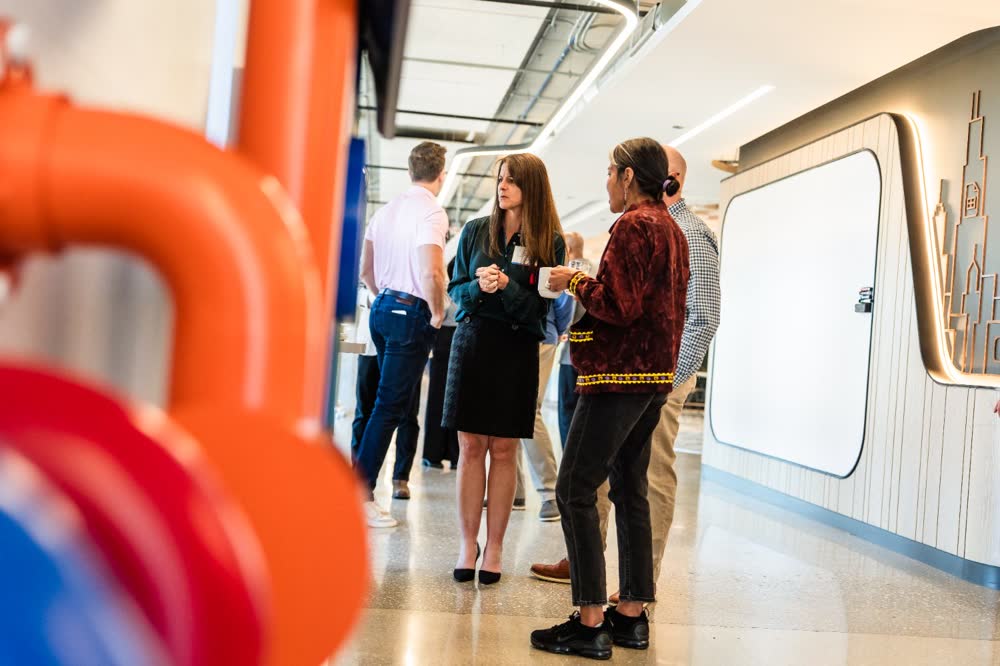 Guests talk over coffee during a networking event, photographed by Jorge Amaya