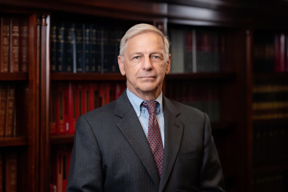 A professional portrait, photographed on location in an office library.